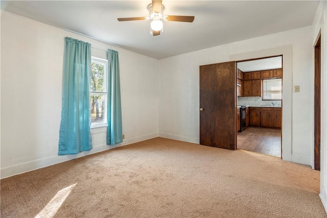 carpeted spare room with ceiling fan