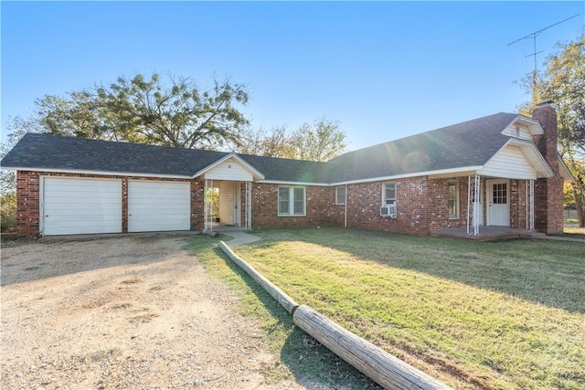 ranch-style home featuring covered porch, a garage, and a front lawn