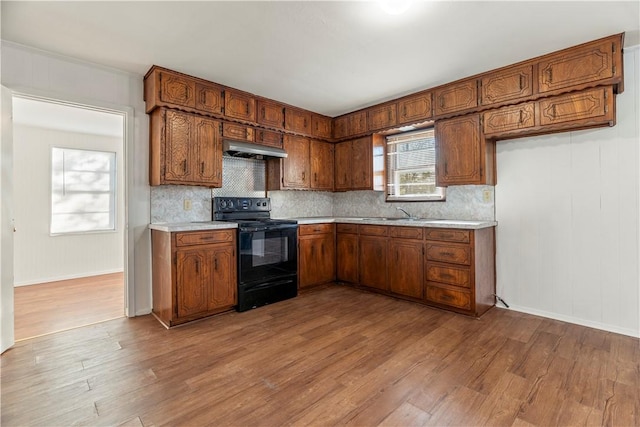 kitchen with backsplash, light hardwood / wood-style floors, and black range with electric cooktop