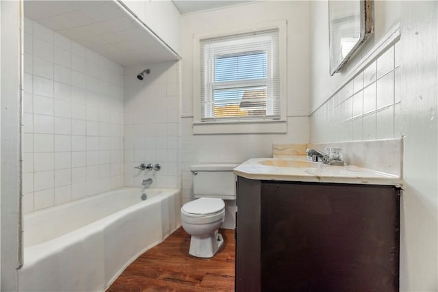 full bathroom with tiled shower / bath, toilet, vanity, and hardwood / wood-style flooring