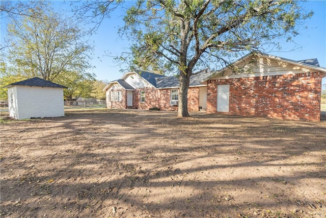 ranch-style house featuring a storage unit