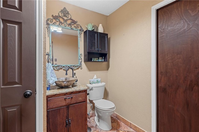 bathroom with tile patterned flooring, vanity, and toilet