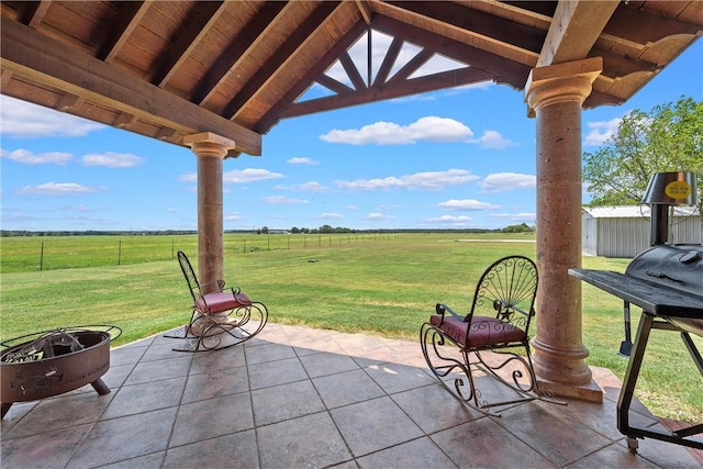 view of patio with a gazebo, a rural view, and an outdoor fire pit