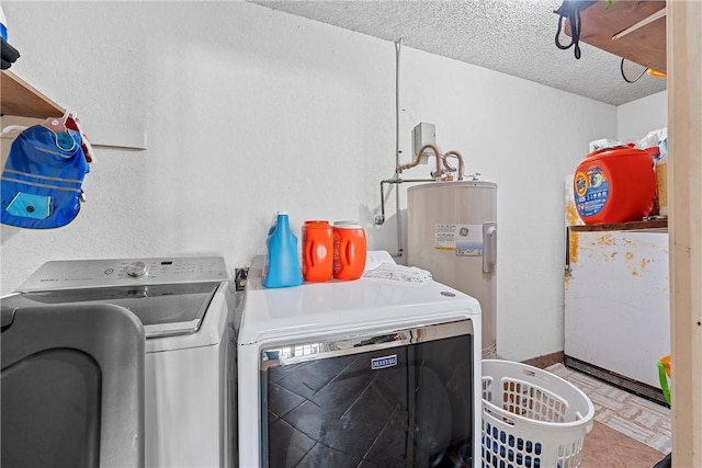 washroom with tile patterned floors, water heater, washer and clothes dryer, and a textured ceiling