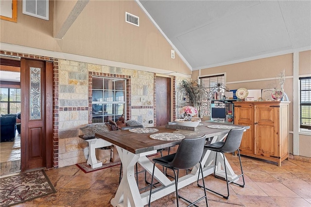 dining room featuring high vaulted ceiling