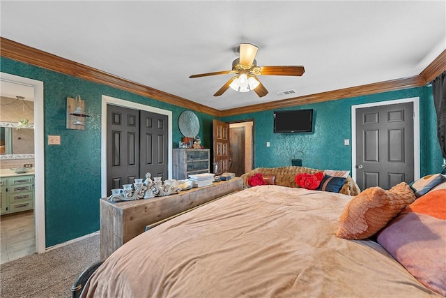 bedroom with carpet floors, connected bathroom, crown molding, and ceiling fan