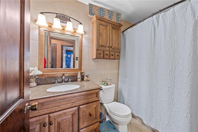 bathroom with tile patterned flooring, vanity, tile walls, and toilet