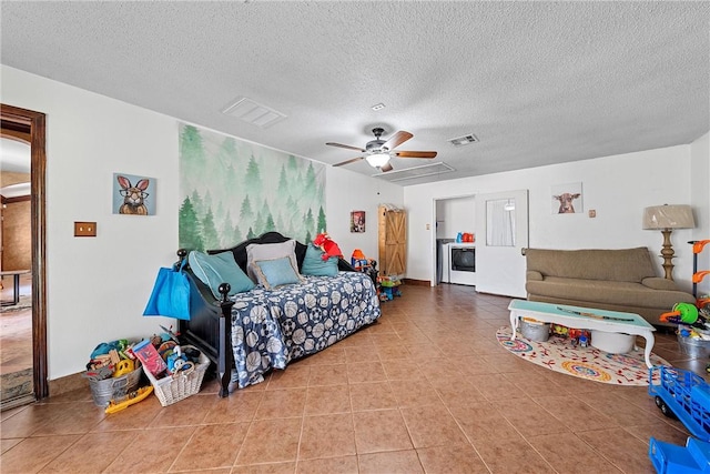 tiled bedroom featuring washer / dryer, a textured ceiling, and ceiling fan