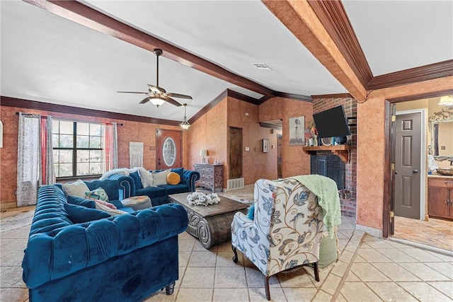 tiled living room with crown molding, ceiling fan, lofted ceiling with beams, and a brick fireplace