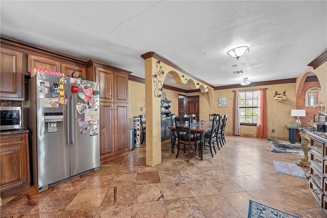 kitchen featuring appliances with stainless steel finishes, a textured ceiling, and crown molding