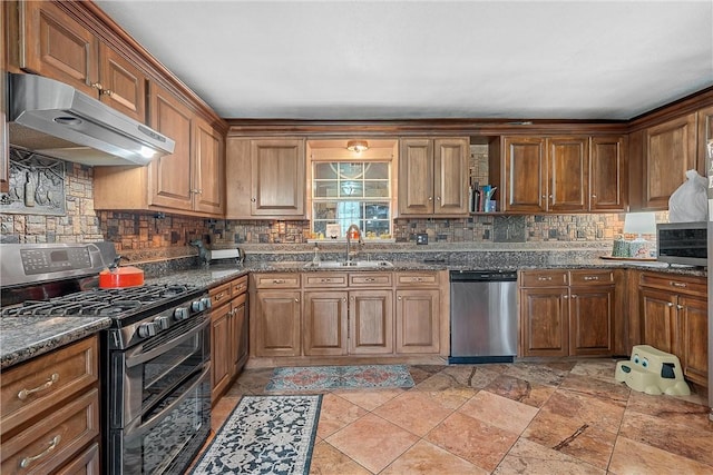 kitchen with dark stone counters, sink, appliances with stainless steel finishes, and tasteful backsplash