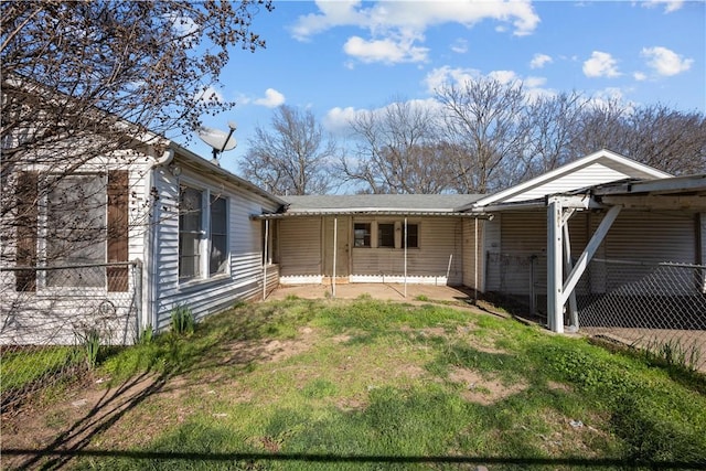 rear view of house with covered porch and a yard