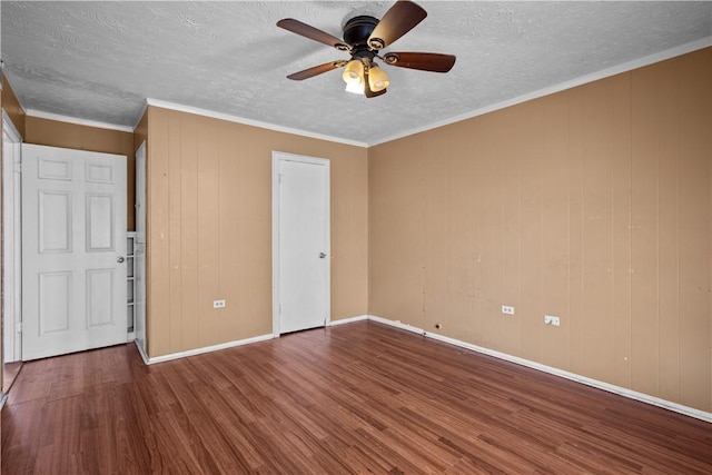 spare room featuring crown molding, a ceiling fan, a textured ceiling, wood finished floors, and baseboards