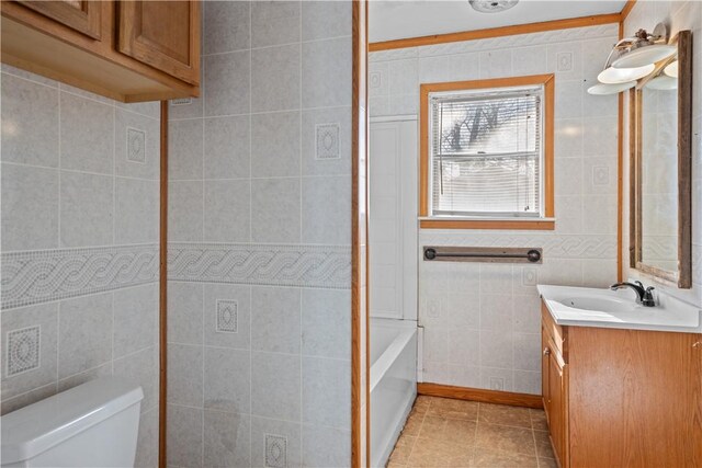 full bath featuring toilet, tile patterned floors, tile walls, and vanity