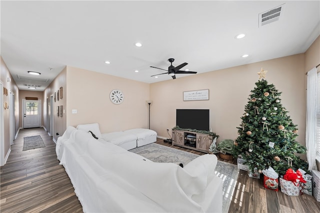 living room with ceiling fan and dark wood-type flooring