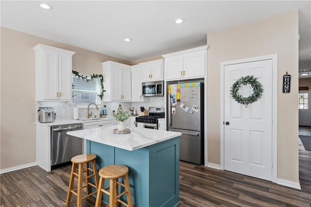 kitchen featuring white cabinetry, sink, a kitchen island, and stainless steel appliances