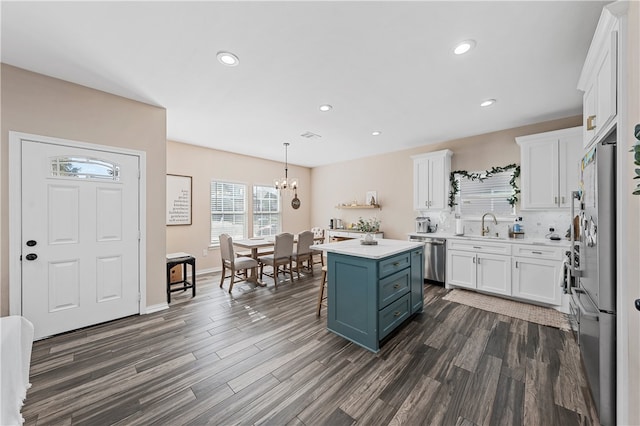 kitchen with white cabinets, a center island, hanging light fixtures, and a breakfast bar area