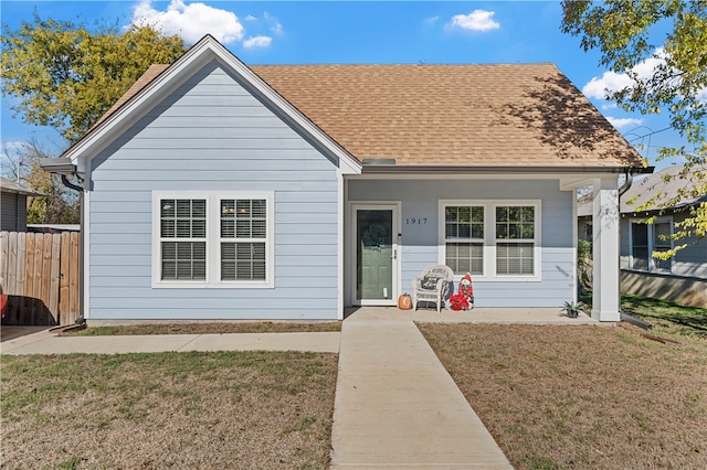 view of front of property featuring covered porch and a front yard