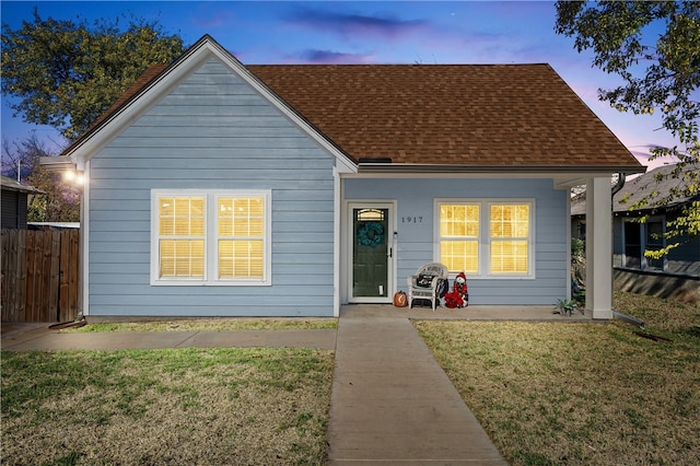 view of front of property featuring covered porch and a yard