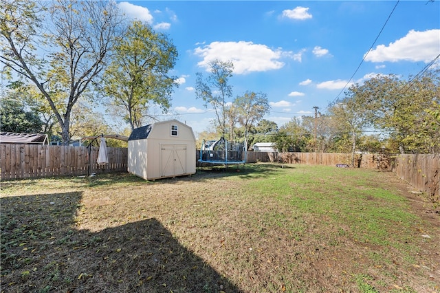 view of yard with a trampoline and a shed