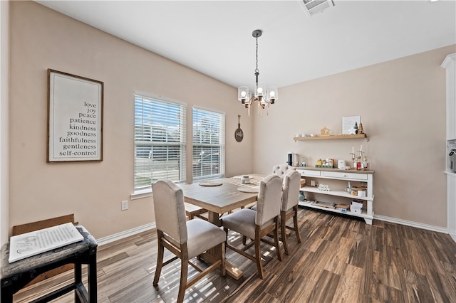 dining area featuring dark hardwood / wood-style flooring and an inviting chandelier