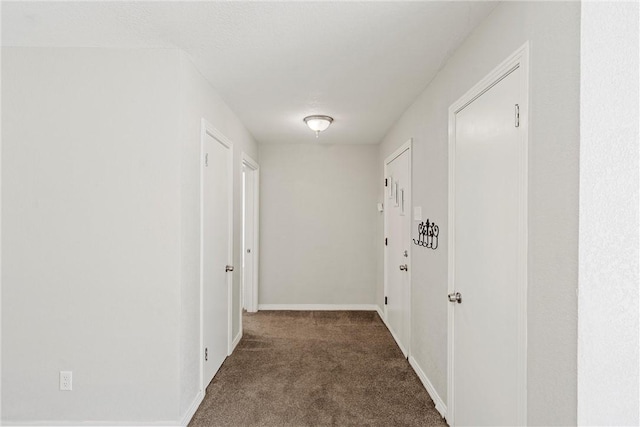 corridor with carpet and baseboards