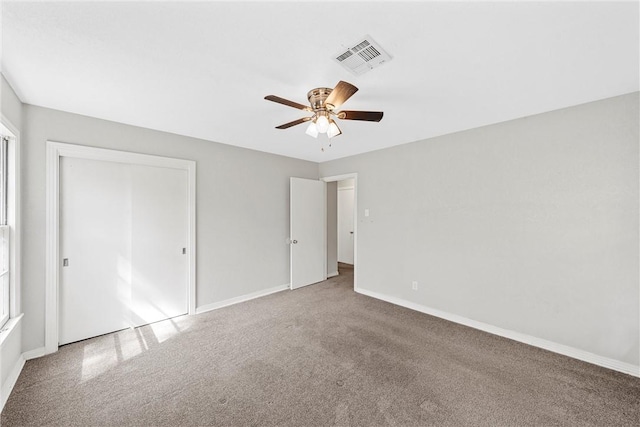 unfurnished bedroom with carpet floors, a closet, visible vents, a ceiling fan, and baseboards