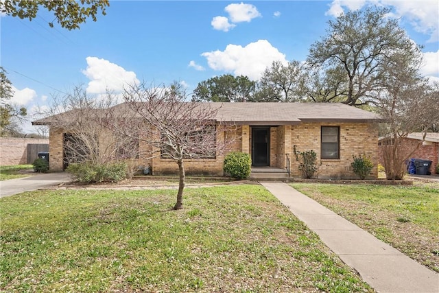 ranch-style house featuring brick siding, concrete driveway, and a front yard