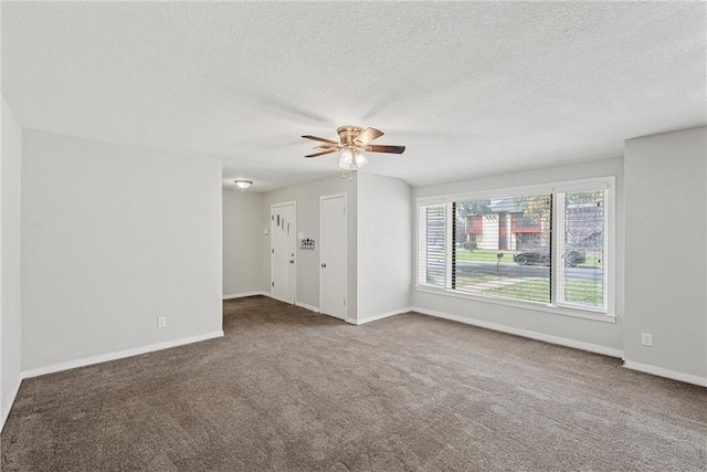 unfurnished room featuring carpet flooring, ceiling fan, a textured ceiling, and baseboards