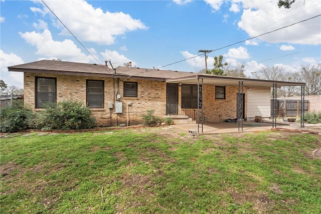 rear view of property with brick siding, a yard, fence, and a patio