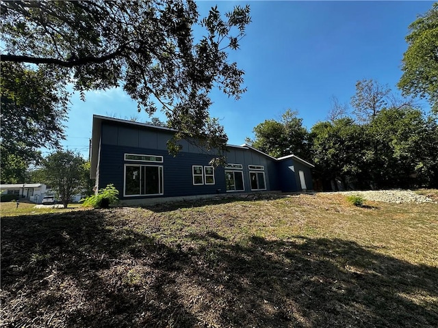 rear view of property with a yard