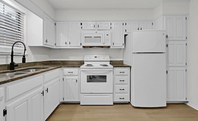 kitchen with white appliances, light wood-style flooring, a sink, and white cabinetry