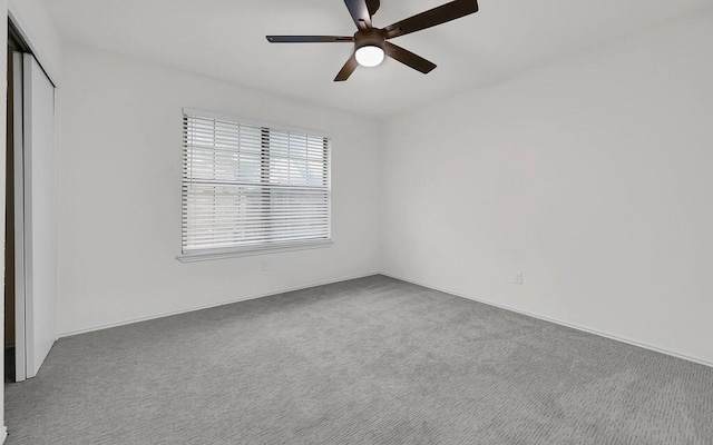 empty room with ceiling fan and carpet floors