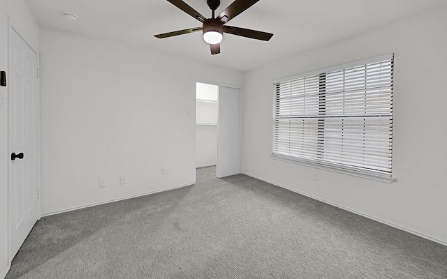 empty room featuring carpet floors and a ceiling fan