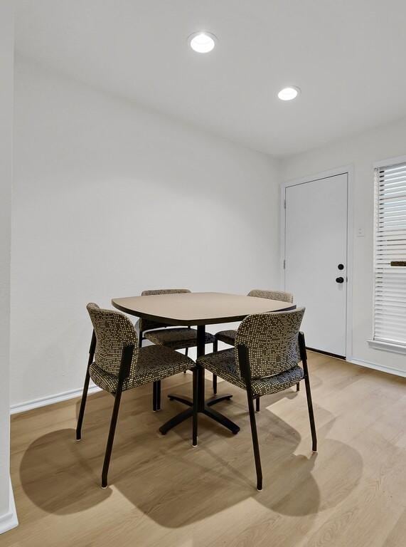 dining room featuring baseboards, light wood finished floors, and recessed lighting