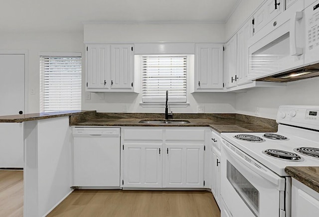 kitchen featuring white appliances, white cabinetry, a sink, and light wood-style flooring