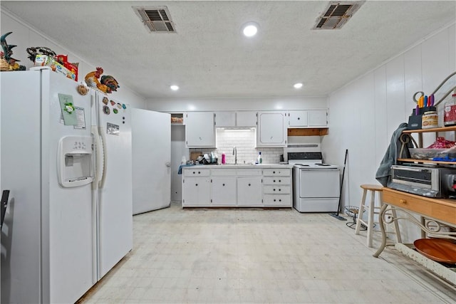 kitchen with a textured ceiling, sink, white cabinets, and white appliances