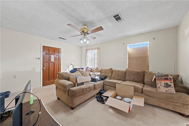 carpeted living room featuring ceiling fan and a textured ceiling