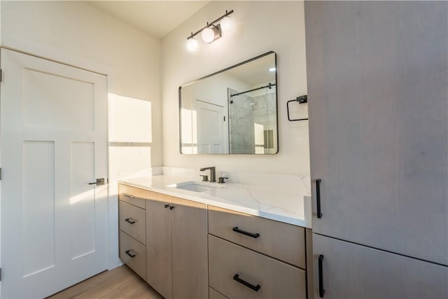 bathroom with vanity, hardwood / wood-style flooring, and a shower with shower door