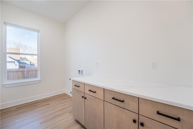 washroom featuring light hardwood / wood-style flooring, cabinets, and washer hookup