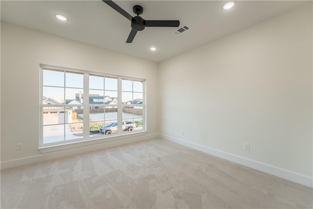 carpeted spare room featuring ceiling fan