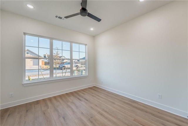 empty room featuring light wood-type flooring, ceiling fan, and a healthy amount of sunlight