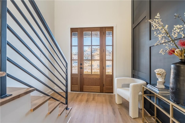 foyer entrance with a high ceiling and light hardwood / wood-style flooring