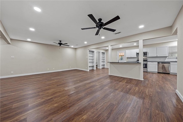 kitchen with visible vents, white cabinets, dark countertops, open floor plan, and stainless steel appliances