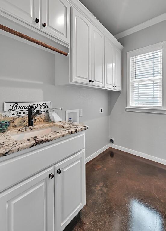 clothes washing area with cabinets, hookup for a washing machine, ornamental molding, electric dryer hookup, and sink