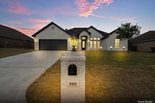 french provincial home with a yard and a garage