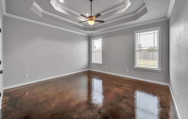 empty room featuring a tray ceiling, crown molding, and ceiling fan