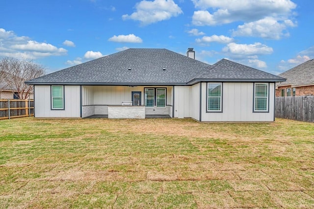 rear view of property with a lawn