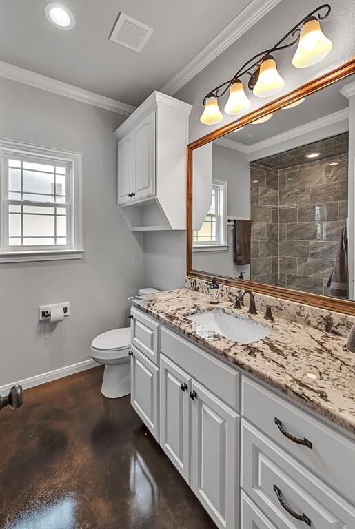 bathroom featuring a wealth of natural light, crown molding, concrete floors, and toilet