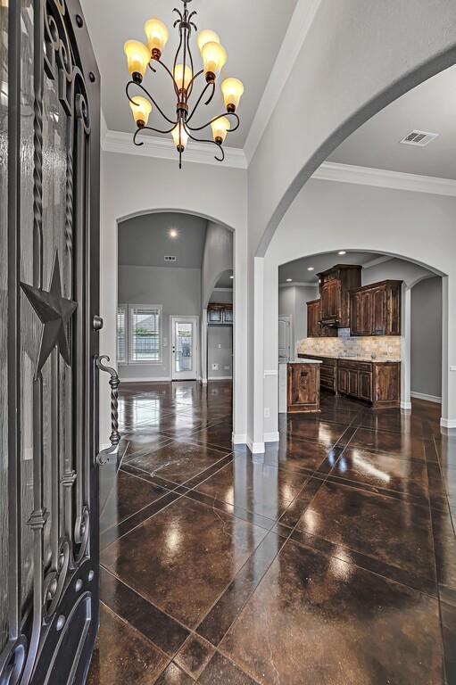 foyer with a notable chandelier and ornamental molding